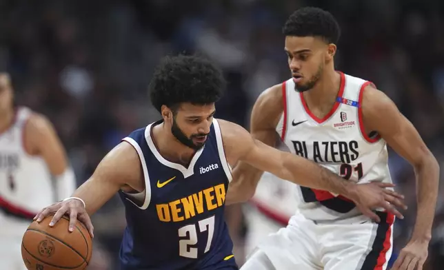 Denver Nuggets guard Jamal Murray, left, collects a loose ball as Portland Trail Blazers guard Rayan Rupert defends in the second half of an NBA basketball game Wednesday, Feb. 12, 2025, in Denver. (AP Photo/David Zalubowski)
