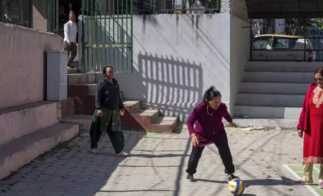 A man watches as women play football during a break at the Ujyalo Community learning center in Kathmandu, Nepal, Feb. 6, 2025. (AP Photo/Niranjan Shrestha)