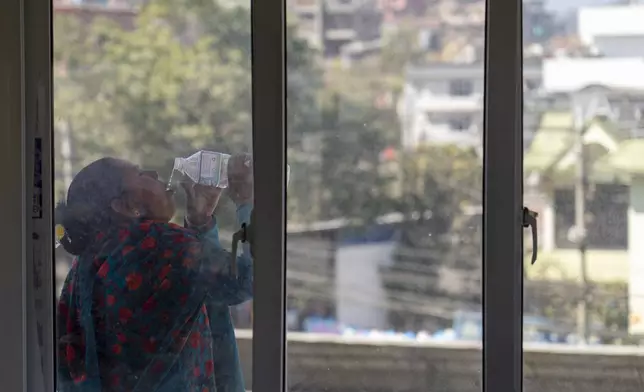 A woman drinks water during a break from her class at the Ujyalo Community learning center in Kathmandu, Nepal, Feb. 3, 2025. (AP Photo/Niranjan Shrestha)