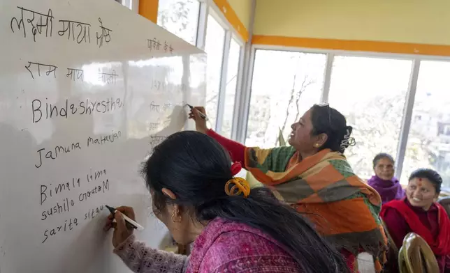 Women write their names on the board during a class at the Ujyalo Community learning center in Kathmandu, Nepal, Feb. 3, 2025. (AP Photo/Niranjan Shrestha)