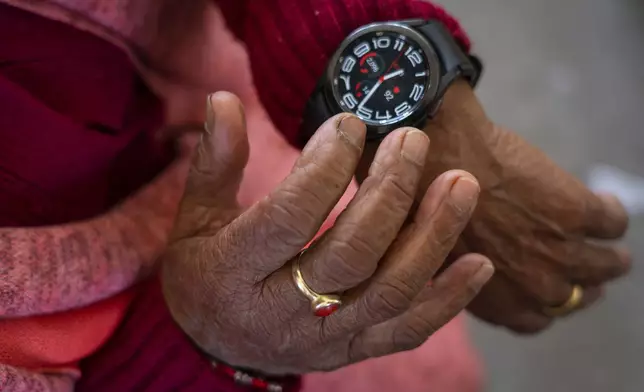 Sushila Gautam, 77, checks her digital watch before attending a class at the Ujyalo Community learning center in Kathmandu, Nepal, Feb. 3, 2025. (AP Photo/Niranjan Shrestha)