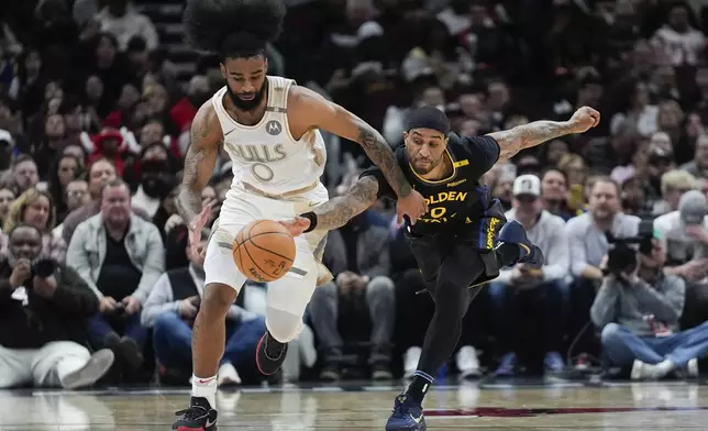 Chicago Bulls guard Coby White, left, and Golden State Warriors guard Gary Payton II, right, chase the ball during the first half of an NBA basketball game Saturday, Feb. 8, 2025, in Chicago. (AP Photo/Erin Hooley)
