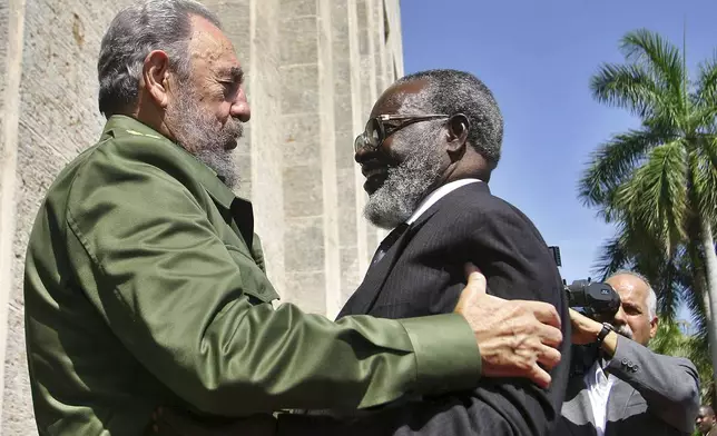 FILE - Cuban President Fidel Castro, left, hugs Namibian President Sam Nujoma during an official welcome ceremony in the state council in Havana, Cuba, June 23, 2004. (Sven Creutzmann/Pool Photo via AP, File)