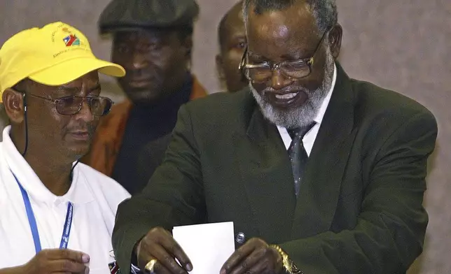 FILE - Namibian President Sam Nujoma, right, casts his vote as an unidentified election worker looks on during the Day 1 of the 2004 elections in Windhoek, Namibia, Nov. 15, 2004. (AP Photo/Themba Hadebe, File)