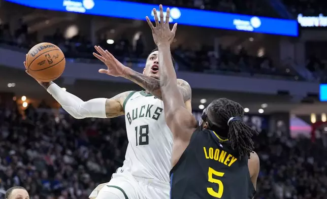 Milwaukee Bucks' Kyle Kuzma (18) looks to shoot against Golden State Warriors' Kevon Looney (5) during the first half of an NBA basketball game Monday, Feb. 10, 2025, in Milwaukee. (AP Photo/Andy Manis)