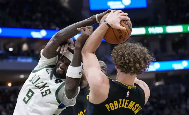 Milwaukee Bucks' Bobby Portis Jr. (9) battles for a rebound against Golden State Warriors' Brandin Podziemski, right, during the first half of an NBA basketball game Monday, Feb. 10, 2025, in Milwaukee. (AP Photo/Andy Manis)