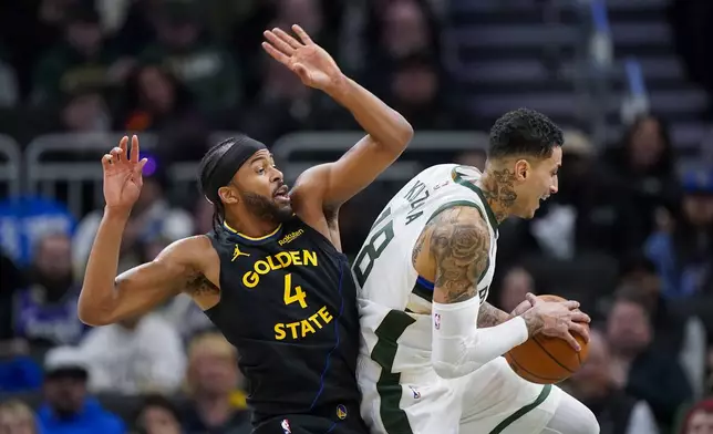 Milwaukee Bucks' Kyle Kuzma, right, grabs a defensive rebound against Golden State Warriors' Moses Moody (4) during the first half of an NBA basketball game Monday, Feb. 10, 2025, in Milwaukee. (AP Photo/Andy Manis)
