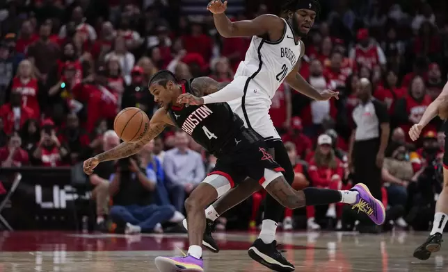 Houston Rockets guard Jalen Green (4) loses control of the ball while defended by Brooklyn Nets center Day'Ron Sharpe (20) during the first half of an NBA basketball game in Houston, Saturday, Feb. 1, 2025. (AP Photo/Ashley Landis)