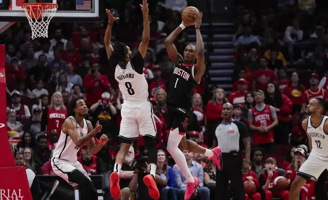 Houston Rockets forward Amen Thompson (1) passes against Brooklyn Nets forward Ziaire Williams (8) during the first half of an NBA basketball game in Houston, Saturday, Feb. 1, 2025. (AP Photo/Ashley Landis)