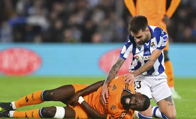 Real Sociedad's Brais Mendez, right, comforts Real Madrid's Antonio Rudiger during the Spanish Copa del Rey soccer match between Real Sociedad and Real Madrid at the Reale Arena in San Sebastian, Spain, Wednesday, Feb. 26, 2025. (AP Photo/Miguel Oses)