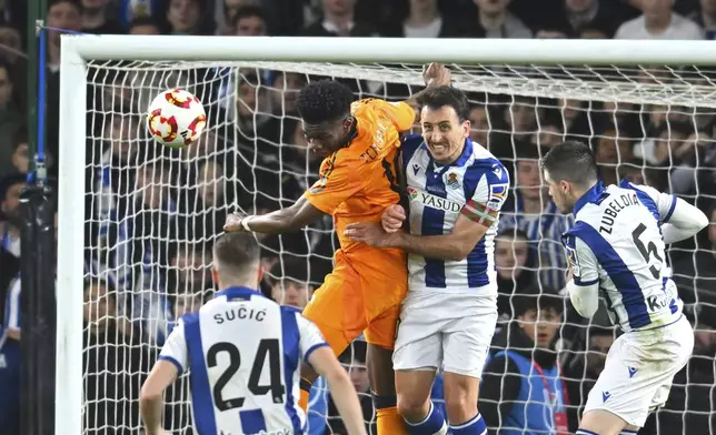 Real Sociedad's Mikel Oyarzabal, centre, challenges for the ball with Real Madrid's Aurelien Tchouameni during the Spanish Copa del Rey soccer match between Real Sociedad and Real Madrid at the Reale Arena in San Sebastian, Spain, Wednesday, Feb. 26, 2025. (AP Photo/Miguel Oses)