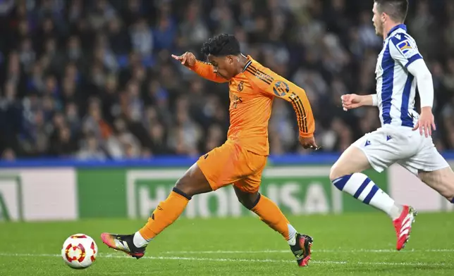 Real Madrid's Endrick, left, scores his side's opening goal during the Spanish Copa del Rey soccer match between Real Sociedad and Real Madrid at the Reale Arena in San Sebastian, Spain, Wednesday, Feb. 26, 2025. (AP Photo/Miguel Oses)