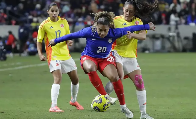 United States forward Catarina Macario (20) blocks out Colombia midfielder Marcela Restrepo, right, as defender Carolina Arias (17) looks on during the SheBelieves Cup women's soccer tournament, Thursday, Feb. 20, 2025, in Houston. (AP Photo/Michael Wyke)
