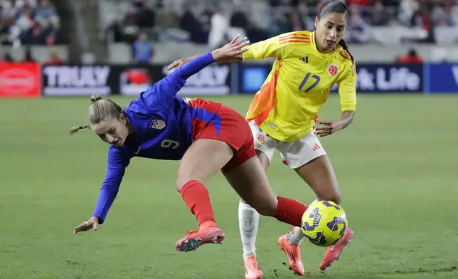 United States forward Ally Sentnor (9) falls as she battles for the ball with Colombia defender Carolina Arias (17) during the SheBelieves Cup women's soccer tournament, Thursday, Feb. 20, 2025, in Houston. (AP Photo/Michael Wyke)