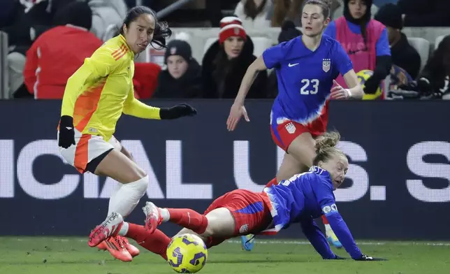 United States defender Emily Sonnett, right, falls on the attempted steal from Colombia forward Mayra Ramirez, left, as defender Emily Fox (23) looks on during the SheBelieves Cup women's soccer tournament, Thursday, Feb. 20, 2025, in Houston. (AP Photo/Michael Wyke)