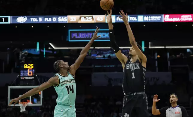 San Antonio Spurs center Victor Wembanyama (1) shoots over Charlotte Hornets forward Moussa Diabate (14) during the first half of an NBA basketball game in Charlotte, N.C., Friday, Feb. 7, 2025. (AP Photo/Nell Redmond)