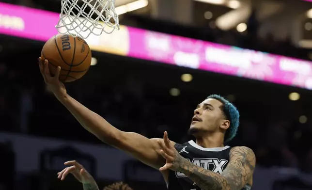 San Antonio Spurs forward Jeremy Sochan drives to the basket against the Charlotte Hornets during the first half of an NBA basketball game in Charlotte, N.C., Friday, Feb. 7, 2025. (AP Photo/Nell Redmond)