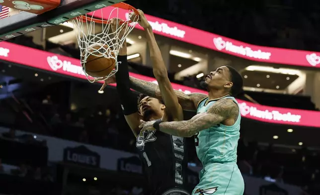 San Antonio Spurs center Victor Wembanyama (1) dunks against Charlotte Hornets guard DaQuan Jeffries during the first half of an NBA basketball game in Charlotte, N.C., Friday, Feb. 7, 2025. (AP Photo/Nell Redmond)
