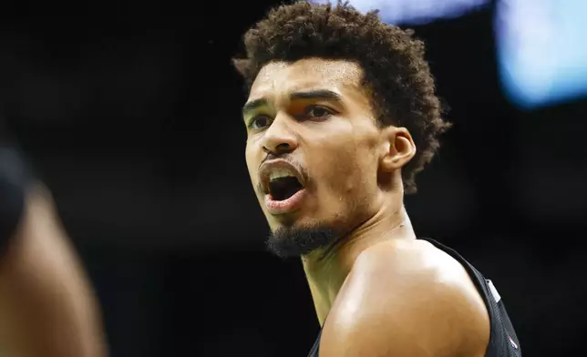 San Antonio Spurs center Victor Wembanyama talks during the first half of an NBA basketball game against the Charlotte Hornets in Charlotte, N.C., Friday, Feb. 7, 2025. (AP Photo/Nell Redmond)