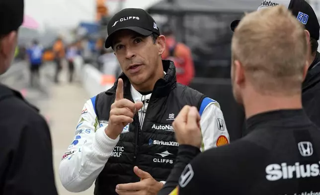 FILE - Helio Castroneves, of Brazil, talks with other drivers during a practice session for the Indianapolis 500 auto race at Indianapolis Motor Speedway, Tuesday, May 14, 2024, in Indianapolis. (AP Photo/Darron Cummings, File)