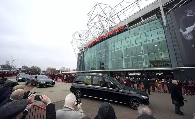 The funeral procession for Denis Law passes Old Trafford, Manchester, England, Tuesday, Feb. 11, 2025. (Martin Rickett/PA via AP)