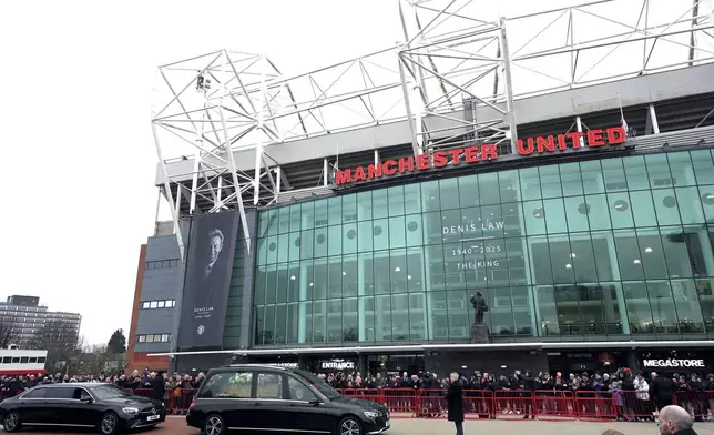 The funeral procession for Denis Law passes Old Trafford, Manchester, England, Tuesday, Feb. 11, 2025. (Martin Rickett/PA via AP)