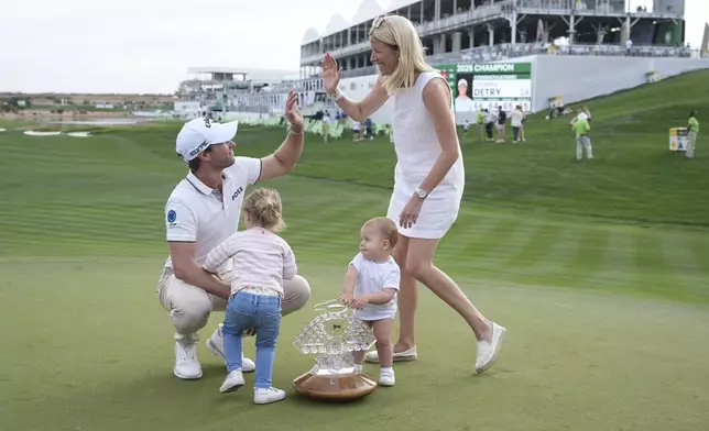 Thomas Detry, left, of Belgium, celebrates after his win at the Phoenix Open golf tournament at TPC Scottsdale with wife Sarah, right, and daughters Sophia, second from left, and Alba, second from right, Sunday, Feb. 9, 2025, in Scottsdale, Ariz. (AP Photo/Ross D. Franklin)