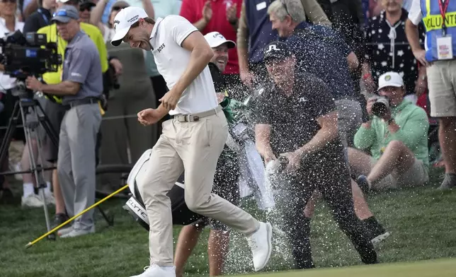 Thomas Detry, left, of Belgium, smiles as he celebrates after his win at the Phoenix Open golf tournament at TPC Scottsdale with fellow golfer Matt Wallace, right, of England, Sunday, Feb. 9, 2025, in Scottsdale, Ariz. (AP Photo/Ross D. Franklin)
