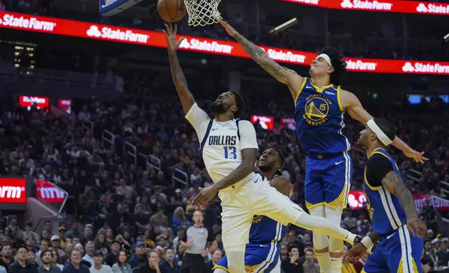 Dallas Mavericks forward Naji Marshall (13) shoots while defended by Golden State Warriors forward Gui Santos (15) during the first half of an NBA basketball game Sunday, Feb. 23, 2025, in San Francisco. (AP Photo/Godofredo A. Vásquez)