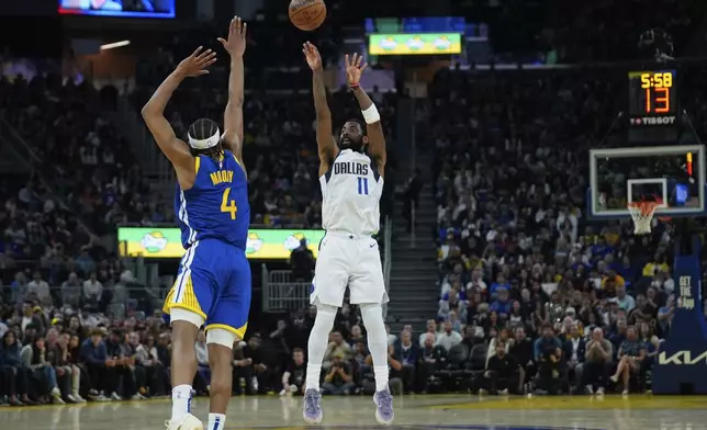 Dallas Mavericks guard Kyrie Irving (11) shoots a 3-point basket over Golden State Warriors guard Moses Moody during the first half of an NBA basketball game Sunday, Feb. 23, 2025, in San Francisco. (AP Photo/Godofredo A. Vásquez)