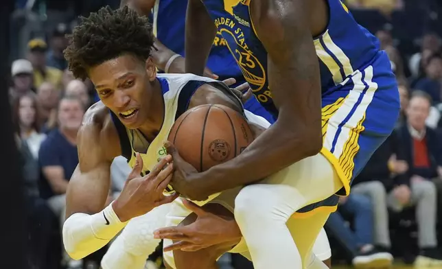 Dallas Mavericks forward Kessler Edwards, left, and Golden State Warriors forward Draymond Green compete for possession of the ball during the first half of an NBA basketball game Sunday, Feb. 23, 2025, in San Francisco. (AP Photo/Godofredo A. Vásquez)
