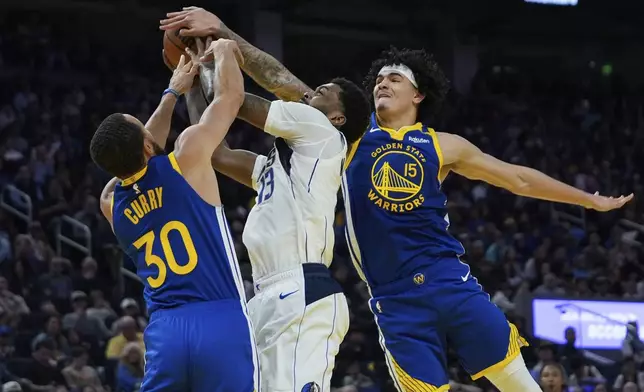 Dallas Mavericks forward Naji Marshall (13) is fouled by Golden State Warriors guard Stephen Curry (30) during the first half of an NBA basketball game Sunday, Feb. 23, 2025, in San Francisco. (AP Photo/Godofredo A. Vásquez)