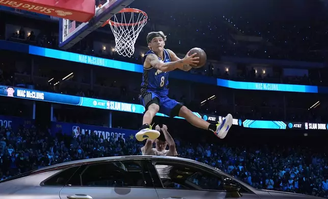 Orlando Magic guard Mac McClung dunks over a car during the slam dunk contest at the NBA basketball All-Star Saturday night festivities Saturday, Feb. 15, 2025, in San Francisco. (AP Photo/Godofredo A. Vásquez)