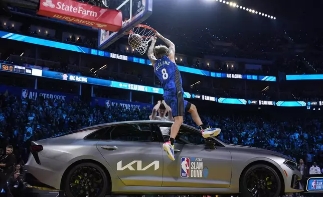 Orlando Magic guard Mac McClung dunks over a car during the slam dunk contest at the NBA basketball All-Star Saturday night festivities Saturday, Feb. 15, 2025, in San Francisco. (AP Photo/Godofredo A. Vásquez)
