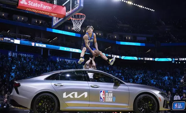Orlando Magic guard Mac McClung dunks over a car during the slam dunk contest at the NBA basketball All-Star Saturday night festivities Saturday, Feb. 15, 2025, in San Francisco. (AP Photo/Godofredo A. Vásquez)