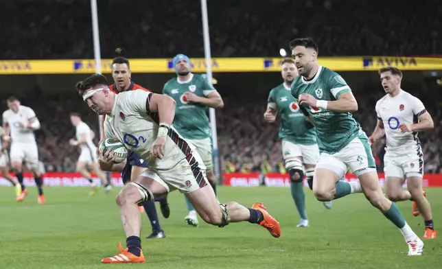 England's Tom Curry crosses the line to score a try during the Six Nations rugby union match between Ireland and England at the Aviva Stadium in Dublin, Saturday, Feb. 1, 2025. (AP Photo/Peter Morrison)