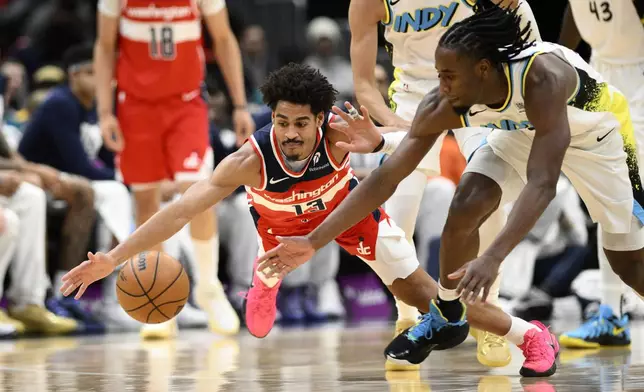 Washington Wizards guard Jordan Poole (dives for the ball against Indiana Pacers forward Aaron Nesmith, right, during the first half of an NBA basketball game, Wednesday, Feb. 12, 2025, in Washington. (AP Photo/Nick Wass)