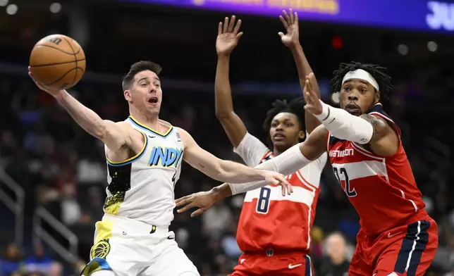 Indiana Pacers guard T.J. McConnell, left, passes the ball against Washington Wizards forward Richaun Holmes (22) and guard Bub Carrington (8) during the first half of an NBA basketball game, Wednesday, Feb. 12, 2025, in Washington. (AP Photo/Nick Wass)