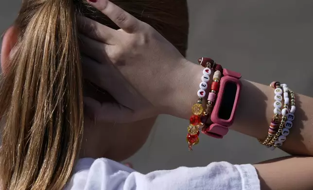 Kansas City Chiefs fan Rose Loftus, 9, from Dallas, ties her hair while wearing a Taylor Swift friendship bracelet outside of St. Louis Cathedral before the NFL Super Bowl 59 football game between the Chiefs and the Philadelphia Eagles, Sunday, Feb. 9, 2025, in New Orleans. (AP Photo/Julia Demaree Nikhinson)