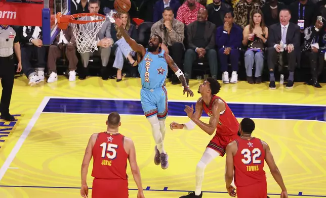 Dallas Mavericks guard Kyrie Irving scores past San Antonio Spurs center Victor Wembanyama during the NBA All-Star basketball game Sunday, Feb. 16, 2025, in San Francisco. (AP Photo/Jed Jacobsohn)