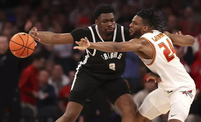 St. John's forward Zuby Ejiofor (24) attempts to steal the ball from Providence forward Christ Essandoko (2) during the second half of an NCAA college basketball game Saturday, Feb. 1, 2025, in New York. (AP Photo/Pamela Smith)