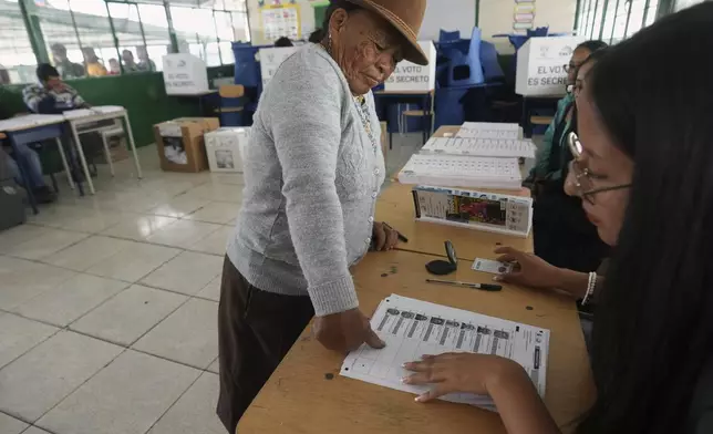 A woman stamps her fingerprint on the voter list during presidential elections in Quito, Ecuador, Sunday, Feb. 9, 2025. (AP Photo/Dolores Ochoa)