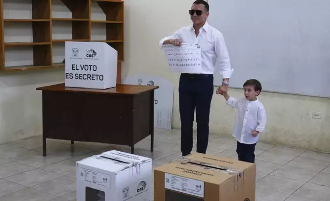 President Daniel Noboa, who is running for reelection, holds up his ballot before voting in the presidential election in Olon, Ecuador, Sunday, Feb. 9, 2025. (AP Photo/Cesar Munoz)