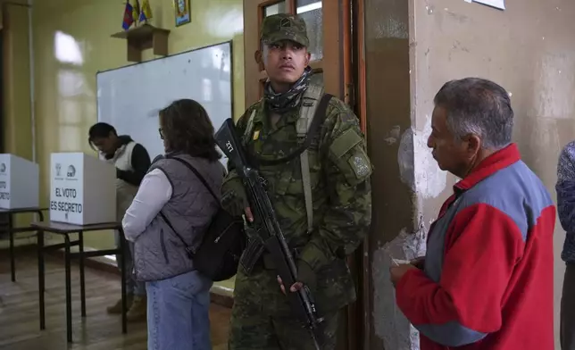 A soldier guards a polling station during presidential elections in Quito, Ecuador, Sunday, Feb. 9, 2025. (AP Photo/Carlos Noriega)