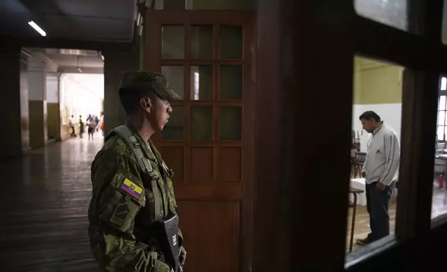 A soldier guards a polling station during presidential elections in Quito, Ecuador, Sunday, Feb. 9, 2025. (AP Photo/Carlos Noriega)
