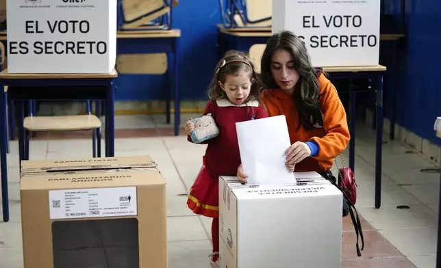 A voter casts her ballot in the presidential election in Quito, Ecuador, Sunday, Feb. 9, 2025. (AP Photo/Dolores Ochoa)