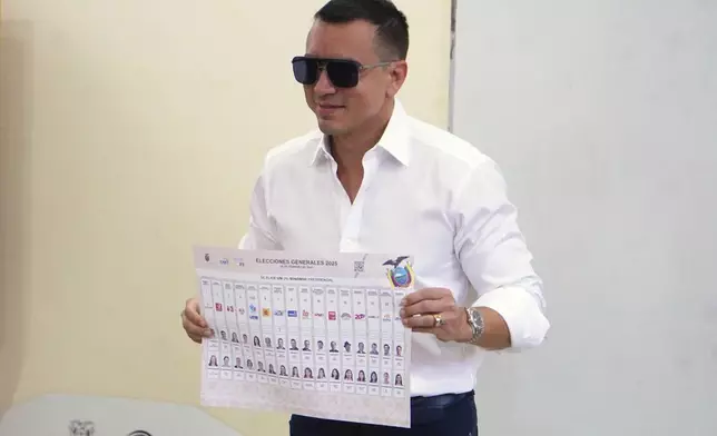 President Daniel Noboa, who is running for reelection, holds up his ballot before voting in the presidential election in Olon, Ecuador, Sunday, Feb. 9, 2025. (AP Photo/Cesar Munoz)