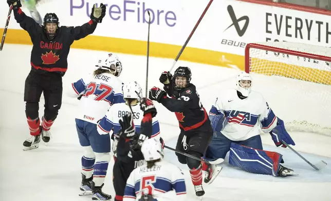 Canada's Marie-Philip Poulin, right, and Laura Stacey, left, celebrate a game-tying goal by teammate Blayre Turnbull during the first period of a women's Rivalry Series hockey game in Halifax, Nova Scotia, Thursday, Feb. 6, 2025. (Darren Calabrese/The Canadian Press via AP)