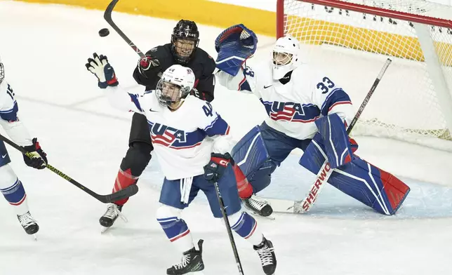 Canada's Laura Stacey, top left, tries to tip the puck in front of USA's goaltender Gwyneth Philips, right, and Sydney Bard during the first period of a women's Rivalry Series hockey game in Halifax, Nova Scotia, Thursday, Feb. 6, 2025. (Darren Calabrese/The Canadian Press via AP)