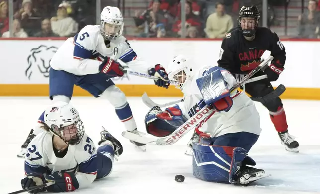 Team USA goaltender Gwyneth Philips makes a save in front of teammates Taylor Heise, left, and Megan Keller as Team Canada's Sarah Fillier, right, looks for a rebound during the second period of of a women's Rivalry Series hockey game in Halifax, Nova Scotia, Thursday, Feb. 6, 2025. (Darren Calabrese/The Canadian Press via AP)
